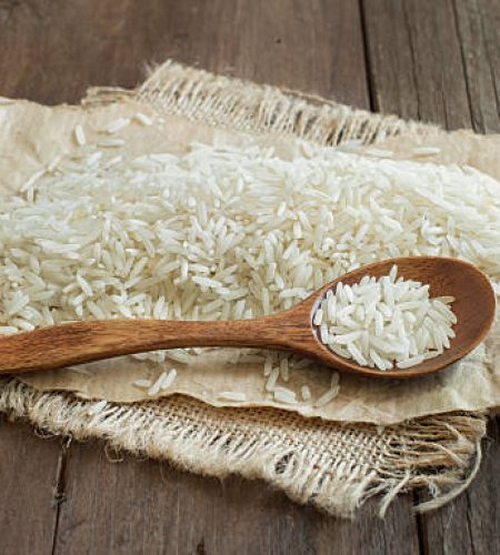 Basmati rice with a spoon on a dark wood